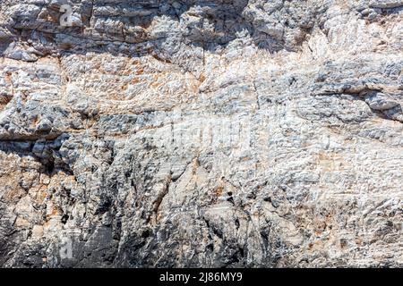 Roccia grigia a forma di mare, sale e vento sullo sfondo texture. Formazione di pietra, materiale minerale grezzo. Superficie rocciosa naturale astratta. Isola greca G Foto Stock