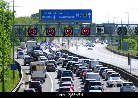 Bristol, Regno Unito. 13th maggio 2022. La fuga del venerdì soleggiato conduce alla congestione sull'autostrada M5. 40 MPH sono in vigore limitazioni di velocità sul tratto gestito dell'autostrada M5 a Filton a causa del volume di traffico che si dirige verso sud verso Devon e Cornovaglia. Nonostante l'elevato costo del carburante, le persone continuano a fare affidamento sulle loro auto. Autostrade Inghilterra rapporto velocità di 12 MPH. Credit: JMF News/Alamy Live News Foto Stock