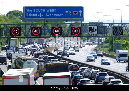 Bristol, Regno Unito. 13th maggio 2022. La fuga del venerdì soleggiato conduce alla congestione sull'autostrada M5. 40 MPH sono in vigore limitazioni di velocità sul tratto gestito dell'autostrada M5 a Filton a causa del volume di traffico che si dirige verso sud verso Devon e Cornovaglia. Nonostante l'elevato costo del carburante, le persone continuano a fare affidamento sulle loro auto. Autostrade Inghilterra rapporto velocità di 12 MPH. Credit: JMF News/Alamy Live News Foto Stock