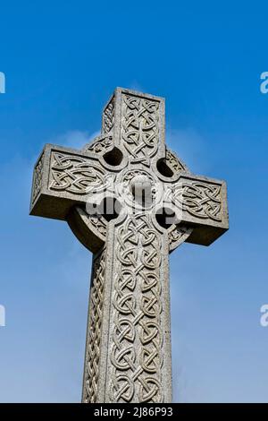 Croce celtica isolata contro il cielo blu profondo Foto Stock