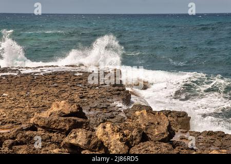 splendide onde panoramiche che si infrangono sulle rocce con spruzzi d'acqua Foto Stock