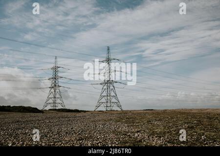 Linee elettriche dalla centrale elettrica di Dungeness B sopra Romney Marsh, Kent Foto Stock