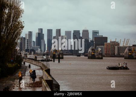 Il Tamigi Barrier con Canary Wharf sullo sfondo, Londra Foto Stock