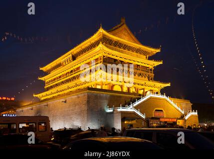 Torre del tamburo di Xi'an di notte; esterno all'esterno dello storico edificio cinese che ospita il tamburo che ha suonato la fine della giornata nella città antica. Cina. Gli aquiloni volano nel cielo in una serata calda. (125) Foto Stock