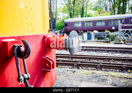 Reepham, Norfolk, Regno Unito – Maggio 08 2022. Focalizzazione ravvicinata e selettiva sui paraurti e gancio sulla parte anteriore di un treno a vapore alloggiato in un cantiere ferroviario disutilizzato Foto Stock
