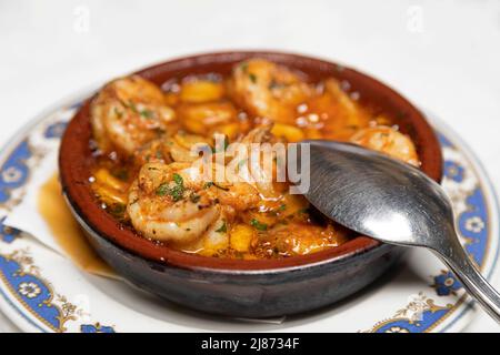 I gamberetti cotti in olio d'oliva con aglio (Gambas al ajillo) serviti come antipasto in un ristorante a Tenerife, Spagna. Il piatto è popolare e tradizionale Foto Stock