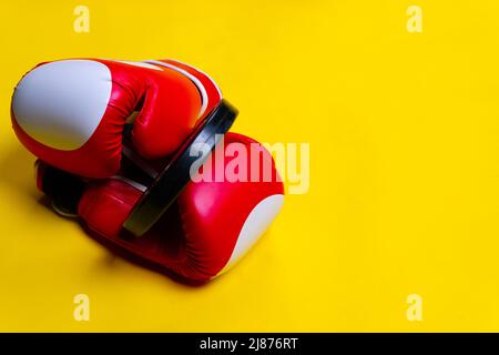 Guanti da boxer giallo pancake rosso passo blu sfondo oggetto, per stile di vita bodybuilding semplice da potenza forte, lotta knockout. Picchiaduro Foto Stock