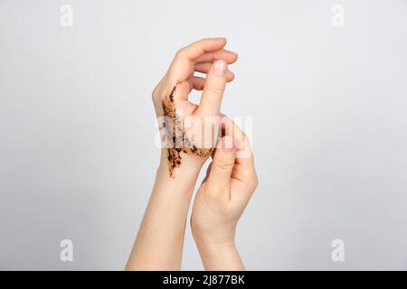 Scrub di caffè sulle mani delle donne, cura della pelle del corpo e delle mani, scrubbing e pilling, un posto per il testo Foto Stock