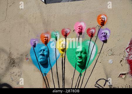 Teste colorate scolpite e dipinte su un muro a Parigi, Francia Foto Stock
