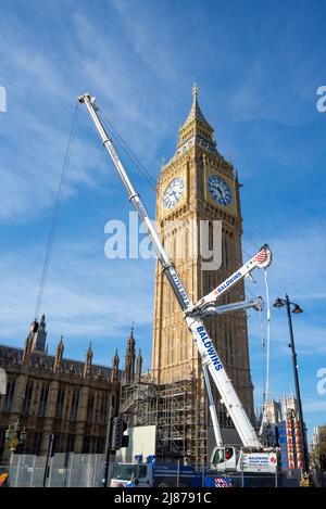 Grande gru Baldwins rimuovere le sezioni finali di impalcatura dalla restaurata Elizabeth Tower, Big ben, del Palazzo di Westminster. Foto Stock