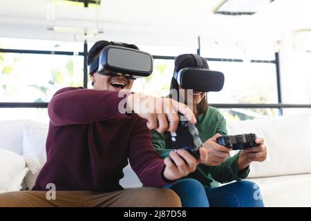 Felice asian giovane coppia giocare video gioco con realtà virtuale a casa Foto Stock