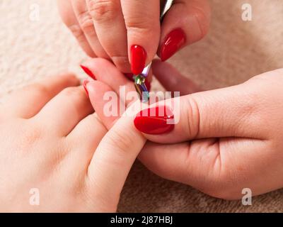 Fare manicure in salone. La preparazione di chiodi per la lucidatura. Foto Stock