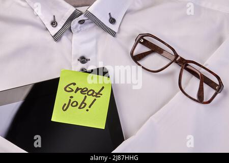 Nota adesiva con tablet e occhiali sulla camicia bianca. Vista dall'alto, disposizione piatta. Foto Stock