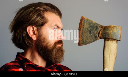 Strumento registratore. Uomo portato in camicia a quadri con ascia. Grumberjack canadese con hatchet. Primo piano verticale. Foto Stock