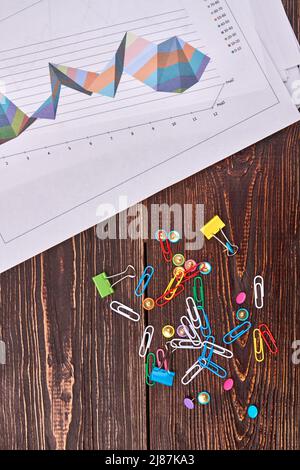 Vista dall'alto della pila di graffette con carta da lavoro. Scrivania in legno marrone. Foto Stock