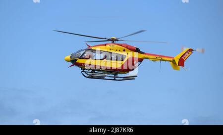 Elicottero della Sécurité Civile (sicurezza civile francese) che vola sulle scogliere di Etretat per aiutare i turisti in difficoltà. Foto Stock