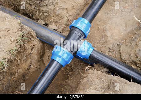 Installazione di tubi dell'acqua in PVC in trincea in cantiere Foto Stock