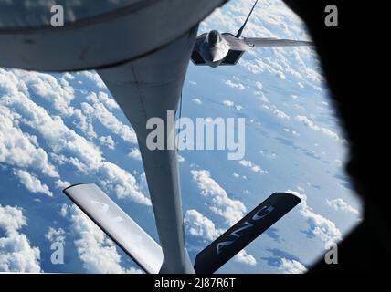 Un pilota dell'aeronautica degli Stati Uniti F-22 Raptor si avvicina al KC-135 Stratotanker assegnato all'ala di rifornimento dell'aria 117th, la Guardia nazionale dell'aria dell'Alabama, durante un'esercitazione di rifornimento al largo della costa di Jacksonville, Florida per Sentry Savannah 22-1 il 12 maggio 2022. Esercizi come Sentry Savannah tenuti presso l'Air Dominance Center non solo addestrano e testano le capacità di contro-aria della prossima generazione di piloti da caccia, ma forniscono anche esperienza critica e formazione a 10 diverse unità di manutenzione Airmen nella rapida occupazione e recupero di velivoli. Foto Stock