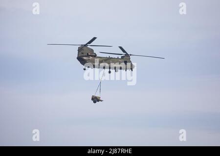Viste da Yelland Quay nel North Devon come Chinook militare esercizio volare da RMB Chivenor su Braunton Burrows. L'elicottero è stato visto trasportare un Land Rover Defender e Trailer avanti e indietro dal Braunton Burrows a RMB Chivenor, Devon, Regno Unito caratterizzato: View, Royal Marines dove: Yelland, Devon, Regno Unito quando: 24 Mar 2021 credito: Upright medial/WENN Foto Stock