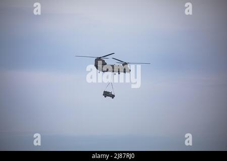 Viste da Yelland Quay nel North Devon come Chinook militare esercizio volare da RMB Chivenor su Braunton Burrows. L'elicottero è stato visto trasportare un Landrover Defender e Trailer avanti e indietro dal Braunton Burrows a RMB Chivenor, Devon, Regno Unito caratterizzato: View, Royal Marines dove: Yelland, Devon, Regno Unito quando: 24 Mar 2021 credito: Upright medial/WENN Foto Stock