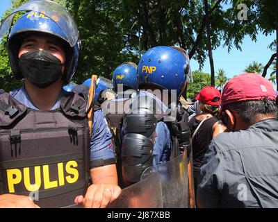 I membri dell'unità di gestione dei disturbi civili (CDM) sono in guardia durante la dimostrazione. Gli attivisti dei gruppi giovanili hanno organizzato una protesta del Black Friday contro il Philippine International Convention Center (PICC), ma sono stati bloccati dalle unità della polizia nazionale filippina (PNP) e della gestione dei disturbi civili (CDM) prima di raggiungere l'edificio. Così i manifestanti hanno appena fatto il loro programma al Centro Culturale del complesso delle Filippine. I manifestanti sono contrari al risultato delle Filippine 9th maggio: Elezioni presidenziali. Foto Stock