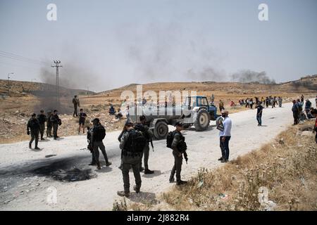 Masafer Yatta, Palestina. 13th maggio 2022. I manifestanti lasciano la strada per permettere che un serbatoio d'acqua da Masafer Yatta venga riempito nella vicina città di Yatta per i villaggi palestinesi che stanno affrontando una carenza di strutture idriche. Una protesta di solidarietà contro gli attivisti di pace israeliani e i residenti di Masafer Yatta che si trovano di fronte a una minaccia immediata di deportazione. Un recente verdetto della Corte Suprema israeliana stabilisce che otto comunità siano espulse da tempo in Palestina da Masafer Yatta. Credit: SOPA Images Limited/Alamy Live News Foto Stock