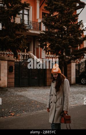 Moda stile di strada in freddo tempo di caduta di una giovane ragazza per strada Foto Stock