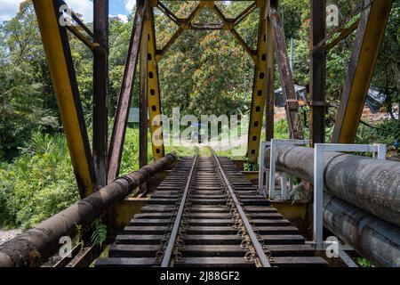 Una corsa Brujita sulla strada ferroviaria attraverso un ponte. San Cipriano, Colombia, Sud America. Foto Stock