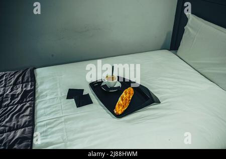 Vassoio di caffè in legno sul letto. Foto Stock
