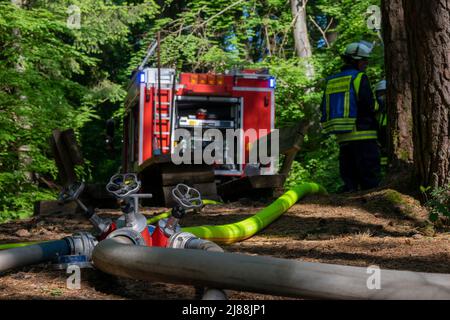 Kordel, Germania. 14th maggio 2022. I vigili del fuoco sono occupati estinguendo gli incendi in una foresta vicino Kordel. Su un punto panoramico sopra la grotta di Genoveva, sono stati impiegati circa 60 addetti alle emergenze dei vigili del fuoco volontari della comunità circostante per spegnere il fuoco e impedire la propagazione delle fiamme. Credit: Harald Tittel/dpa/Alamy Live News Foto Stock