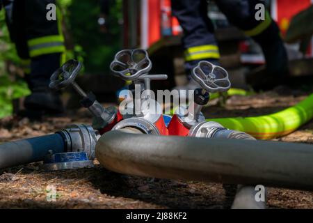 Kordel, Germania. 14th maggio 2022. I vigili del fuoco sono impegnati in operazioni di estinzione in una foresta. Su un punto panoramico sopra la grotta di Genoveva, circa 60 persone di emergenza provenienti dai vigili del fuoco volontari del comune circostante sono stati schierati per spegnere il fuoco e prevenire la diffusione delle fiamme. Credit: Harald Tittel/dpa/Alamy Live News Foto Stock