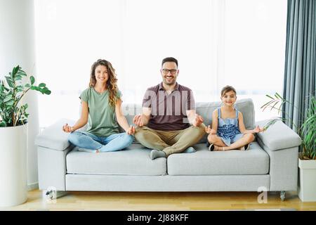 bambino yoga famiglia madre casa donna esercizio ragazza padre fitness insieme figlia Foto Stock