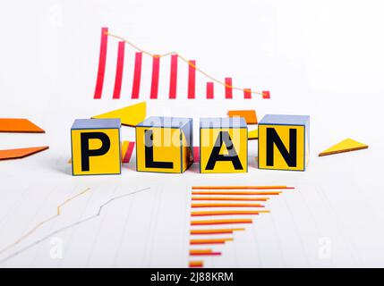 Ripresa della crisi economica. Cubi con piano di parola e grafici che mostrano la recessione nel commercio. Strategia per superare i problemi finanziari e il rallentamento. Foto di alta qualità Foto Stock
