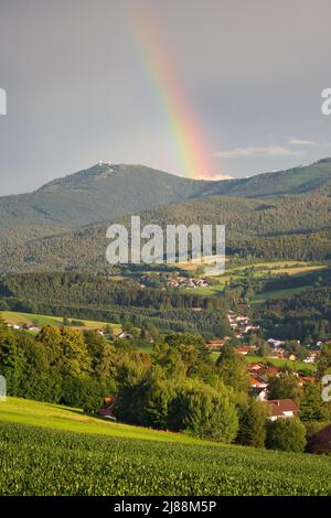 Lam, una piccola città della Baviera in estate dopo una tempesta di tuoni con un arcobaleno. Vista sul monte Großer Arber con le sue due torri. Parte di Lamer Wink Foto Stock