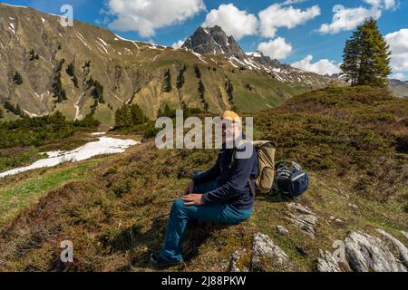 Wanderer mit Sauerstoffunterstützung im Bregenzerwald auf dem Weg zum Körbersee. Nach Covid-19 inkl. 1 Monat Koma ist es die erste Bergtour. Foto Stock