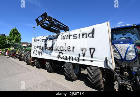 Stoccarda, Germania. 14th maggio 2022. Gli agricoltori si dimostrano con i trattori a Stoccarda-Hohenheim di fronte al luogo d'incontro dei G7 ministri dell'agricoltura. Su un trattore è presente un banner con le parole 'Mr. Özdemir! Non siamo una frangia radicale!!” è allegato. Credit: Bernd Weißbrod/dpa/Alamy Live News Foto Stock
