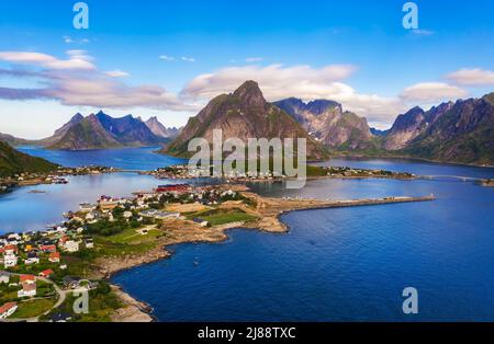 Villaggio di pescatori Reine circondato da alte montagne e fiordi sulle isole Lofoten Foto Stock