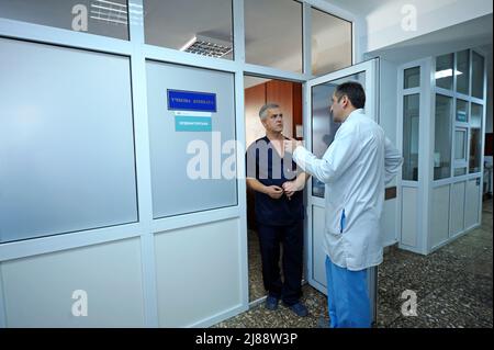 Due uomini in un camice da laboratorio in piedi in un corridoio dell'unità chirurgica e comunicante. Gennaio 12, 2019. Clinica regionale di Kiev 1. Kiev, Ucraina Foto Stock