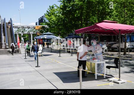 Pechino, Cina. 14th maggio 2022. Un medico prende un campione di tampone da un uomo per il test dell'acido nucleico nella zona di Xidan a Pechino, capitale della Cina, 14 maggio 2022. Credit: Peng Ziyang/Xinhua/Alamy Live News Foto Stock