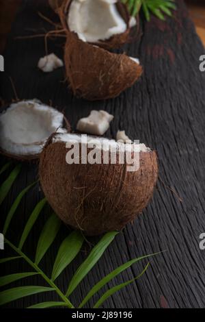 Cocco tritato su sfondo di legno, vista dall'alto. Latte di cocco e fiocchi di cocco sono cibi tropicali Foto Stock