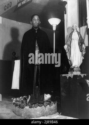 Washington, D.C. il reverendo Vondell Gassaway, pastore della Chiesa spirituale di San Martino in piedi in una ciotola di acqua sacra bannata di rose, ognuno di essi benedice e dà ad un membro che è stato infastidito e pregato da una lunga serie di discepoli durante l'annuale "dimostrazione della ciotola di fiori". Foto Stock