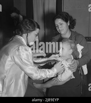 Calipatria, Valle Imperiale. Il medico di salute pubblica visitante conduce la clinica del bene-bambino nell'edificio della scuola locale adiacente al raccolto di piselli. Molte madri migratrici assistono. Foto Stock