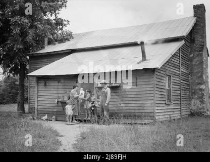 [Untitled, possibilmente relativo a: Sharecropper del tabacco e alla sua famiglia alla parte posteriore della loro casa che mostra la porta della cucina, l'apparecchiatura domestica, il percorso del piede al fienile. Person County, North Carolina]. Foto Stock