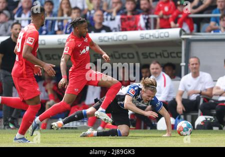 Bielefeld, Germania. 14th maggio 2022. Calcio: Bundesliga, Arminia Bielefeld - RB Leipzig, incontro 34 presso la Schüco Arena. Patrick Wimmer di Bielefeld (r) è stato imbrattato da Christopher Nkunku di Lipsia (2nd da sinistra). Credit: Friso Gentsch/dpa - NOTA IMPORTANTE: In conformità con i requisiti della DFL Deutsche Fußball Liga e della DFB Deutscher Fußball-Bund, è vietato utilizzare o utilizzare fotografie scattate nello stadio e/o della partita sotto forma di immagini di sequenza e/o serie di foto video-simili./dpa/Alamy Live News Foto Stock