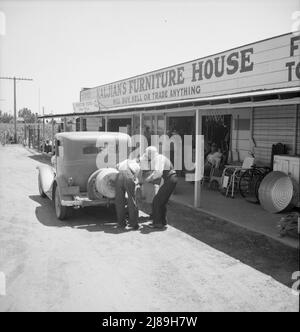 Periferia di Fresno. Sulla U.S. 99. Molte piccole aziende e negozi di seconda dimensione su US 99. Si avvicina a Fresno. [Segno: 'La casa di mobilia del Kaljian - comprerà, venderà o commerci qualche cosa - Stoves, attrezzi di fattoria ']. Foto Stock