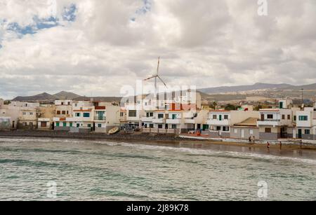 17 Febbraio 2022 Playa Ojos de Garza Canary Spagna, una piccola spiaggia accogliente al mare vicino all'aeroporto con case colorate vicino a cui la marea arriva in c Foto Stock