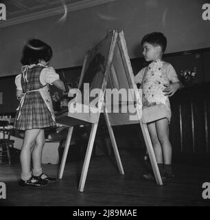 New Britain, Connecticut. Un centro di assistenza bambini, aperto il 15 settembre 1942, per trenta bambini, dai due ai cinque anni, di madri impegnate nell'industria bellica. Orario: Dalle 6:30 alle 6:00, sei giorni alla settimana. Pittura e colorazione bambini. Foto Stock