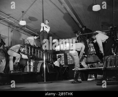 Stazione dei vigili del fuoco No. 4. Washington, D.C. quando il gong suona l'allarme, i vigili del fuoco saltano nei loro stivali ed entrano nei loro caschi e cappotti mentre il camion è sulla sua strada per il fuoco. Una volta che l'allarme è suonato l'operazione completa di vestirsi e lasciare l'edificio richiede circa sette secondi. Foto Stock