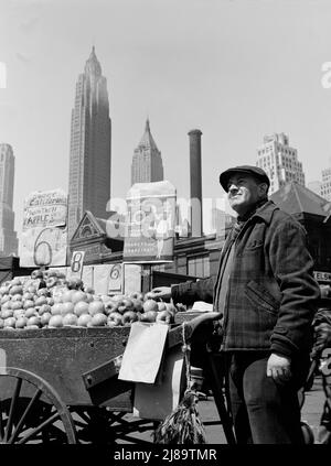 New York, New York. Spingi il venditore di frutta del carrello al mercato del pesce di Fulton. Foto Stock