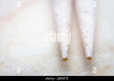 Primo piano estremo di carta artigianale beige con stuzzicadenti. Profondità di campo poco profonda. Foto Stock